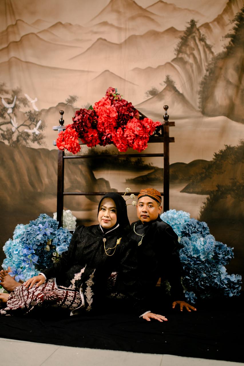 Pasangan berjalan di antara cahaya hangat upacara pernikahan